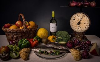 a table topped with a plate of food and a bottle of wine