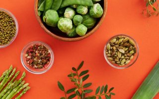 Vibrant display of nutritious vegetables and spices on a bold red background.