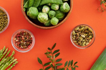 Vibrant display of nutritious vegetables and spices on a bold red background.